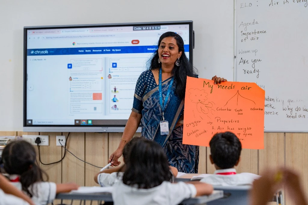 A Wellsprings teacher holding a chart in class.