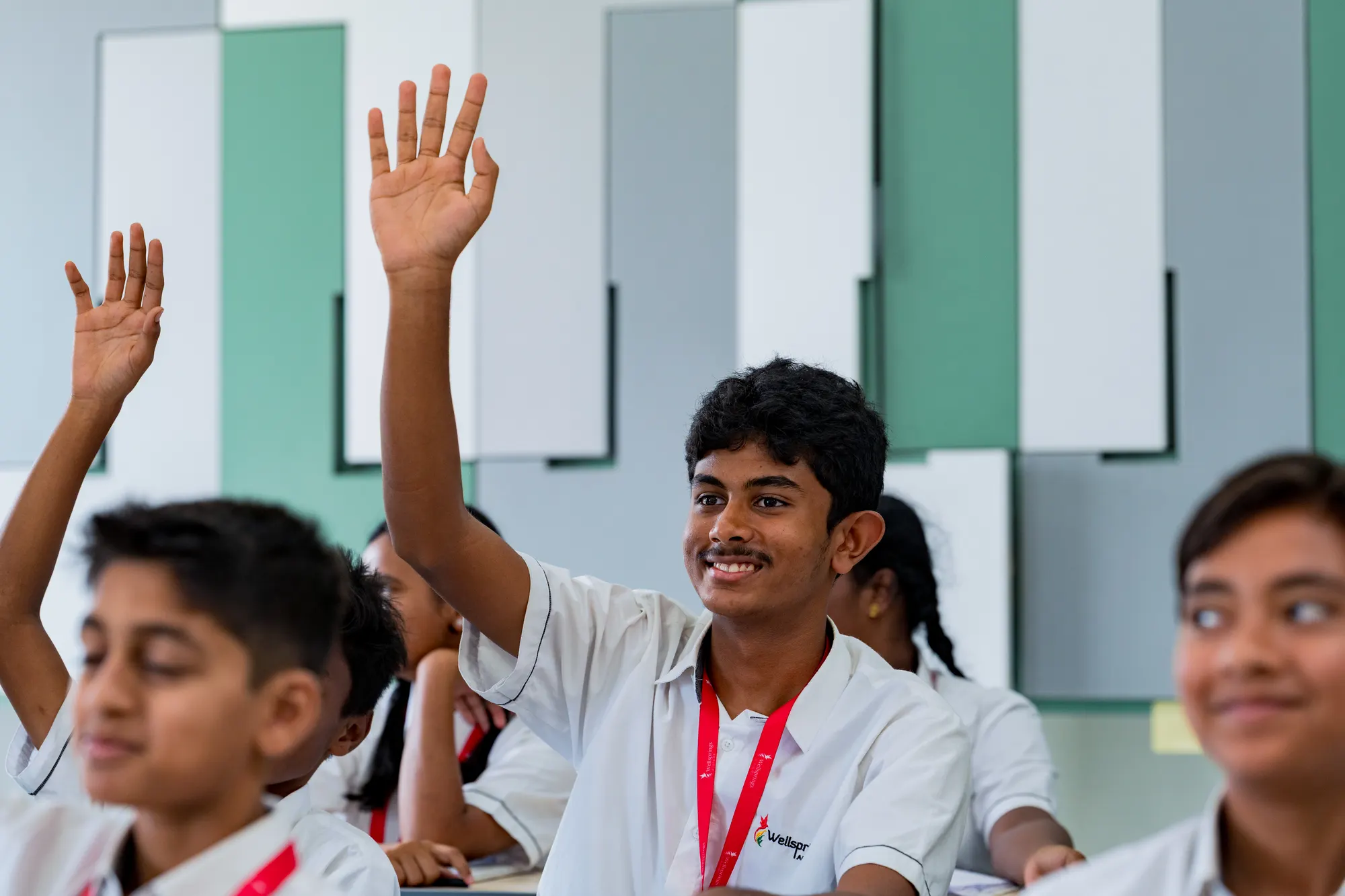 A Wellsprings student raising his hand in class