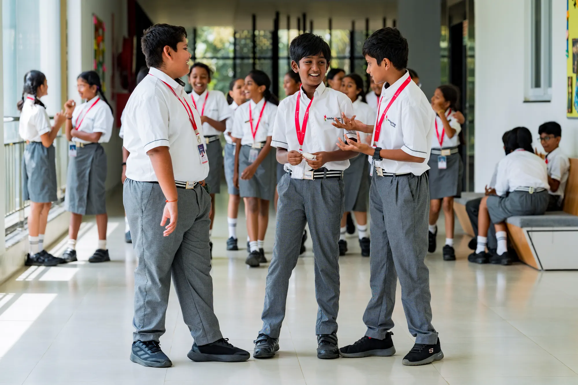 Three Wellsprings students talking together in a corridor