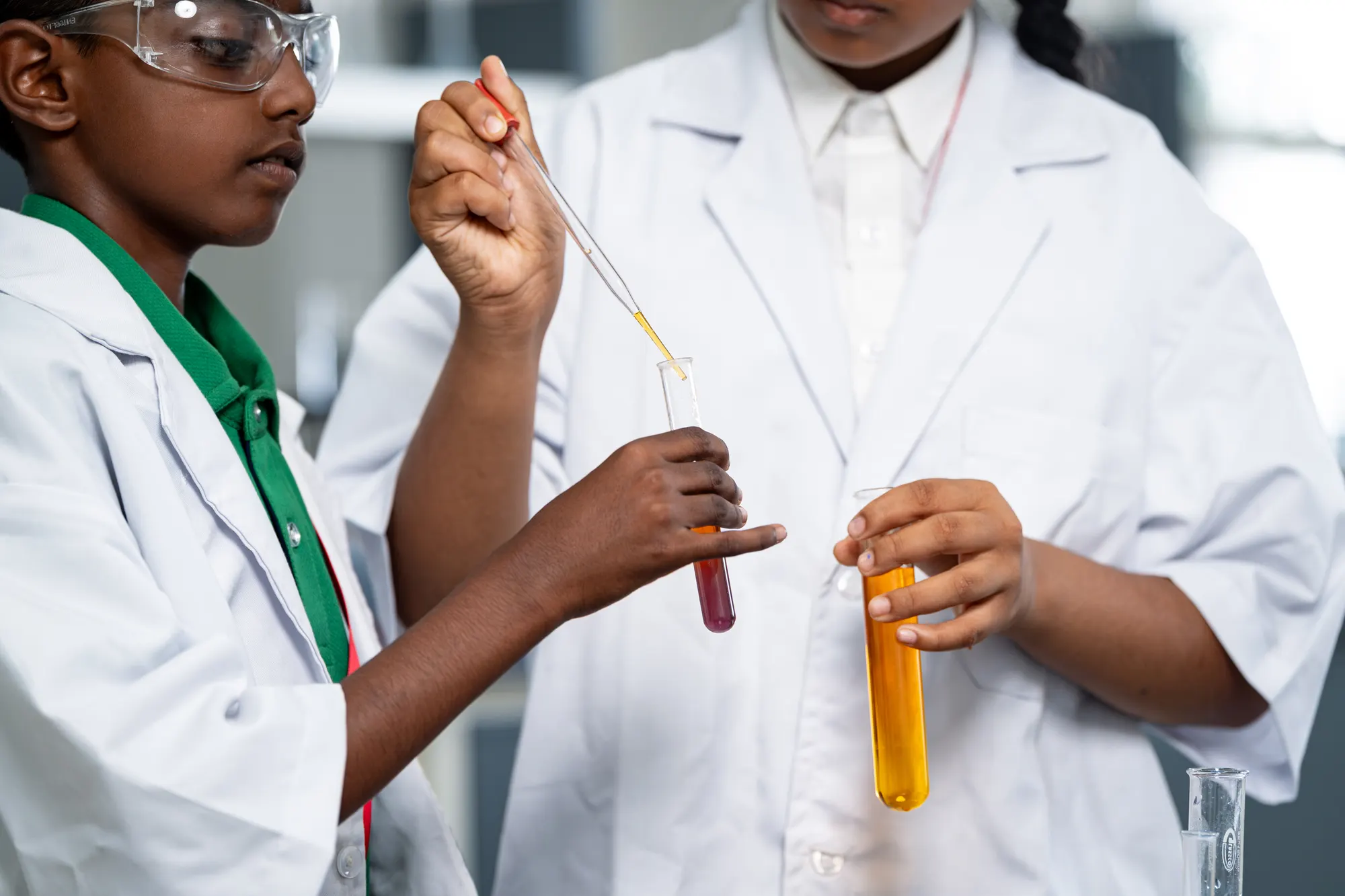 A Wellsprings student measuring liquid into a test tube in the science lab